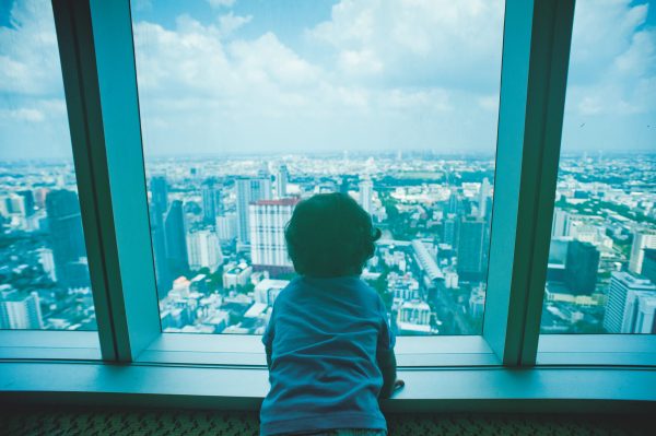 toddler-looking-through-clear-glass-window-1031795
