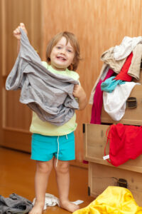 Baby girl chooses dress at closet