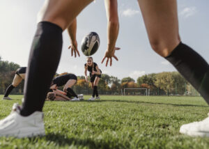 back-view-women-hands-trying-to-catch-a-rugby-ball