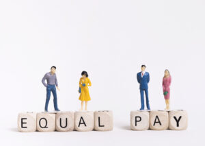 business-man-woman-sitting-wooden-cubes-with-equal-pay-written