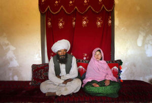 Faiz, 40, and Ghulam, 11, sit in her home prior to their wedding in rural Afghanistan. Ghulam said she is sad to be getting engaged as she wanted to be a teacher. Before she was made to drop out of school her favorite class was Dari, the local language. Married girls are seldom found in school, limiting their economic and social opportunities.