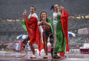 epa09447202 A handout photo made available by OIS/IOC shows winner Ambra Sabatini of Italy celebrating with runner up Martina Caironi of Italy and third place Monica Graziana Contrafatto of Italy at the finish of the Athletics Women's 100m - T63 Final in the Olympic Stadium at the Tokyo 2020 Paralympic Games, Tokyo, Japan, Saturday 04 September 2021.  EPA/Thomas Lovelock for OIS HANDOUT   EDITORIAL USE ONLY/NO SALES