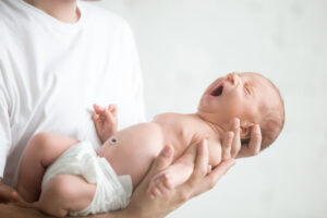 Male hands holding a screaming newborn in a diaper. Family, healthy birth concept photo