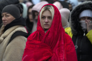 Refugees, mostly women and children, wait for transportation after fleeing from the Ukraine and arriving at the border crossing in Medyka, Poland, Monday, March 7, 2022. Hundreds of thousands of Ukrainian civilians attempting to flee to safety Sunday were forced to shelter from Russian shelling that pummeled cities in Ukraine’s center, north and south. (AP Photo/Markus Schreiber)
