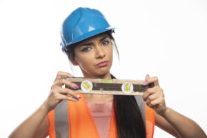 The young charming girl the builder with the measuring tool on white background. High quality photo