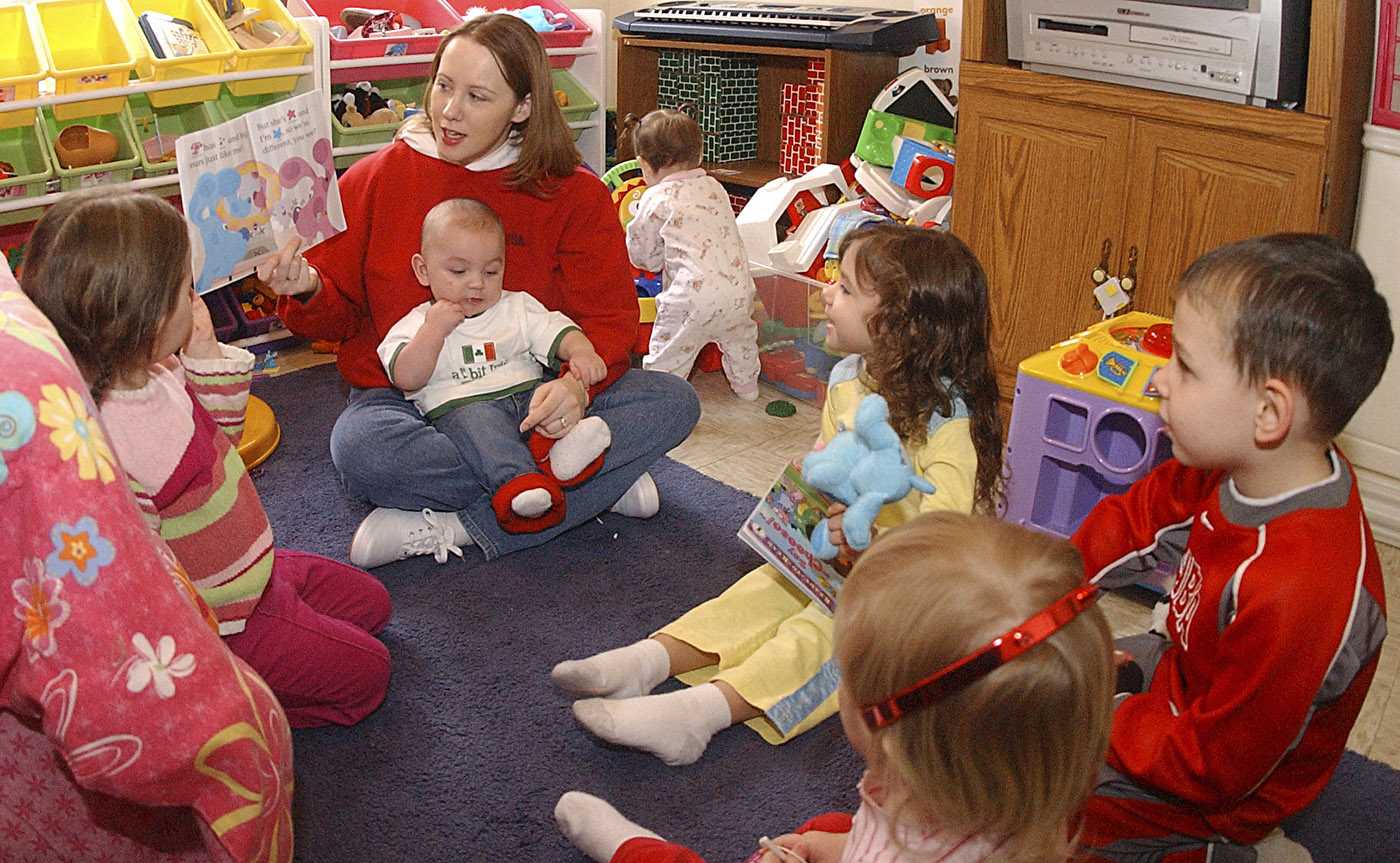 Gina Narvaez, center, reads a Blues Clues book to her daycare children Frida before breakfast. Narvaez, a home child care provider, is one of 15 providers that the child development center has, which is currently at a critical shortage. The maximum capacity of home child care providers is currently 30.