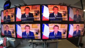 French President Emmanuel Macron is seen as he addresses the nation about the coronavirus disease (COVID-19) outbreak, on television screens in Paris, France, April 13, 2020. REUTERS/Charles Platiau