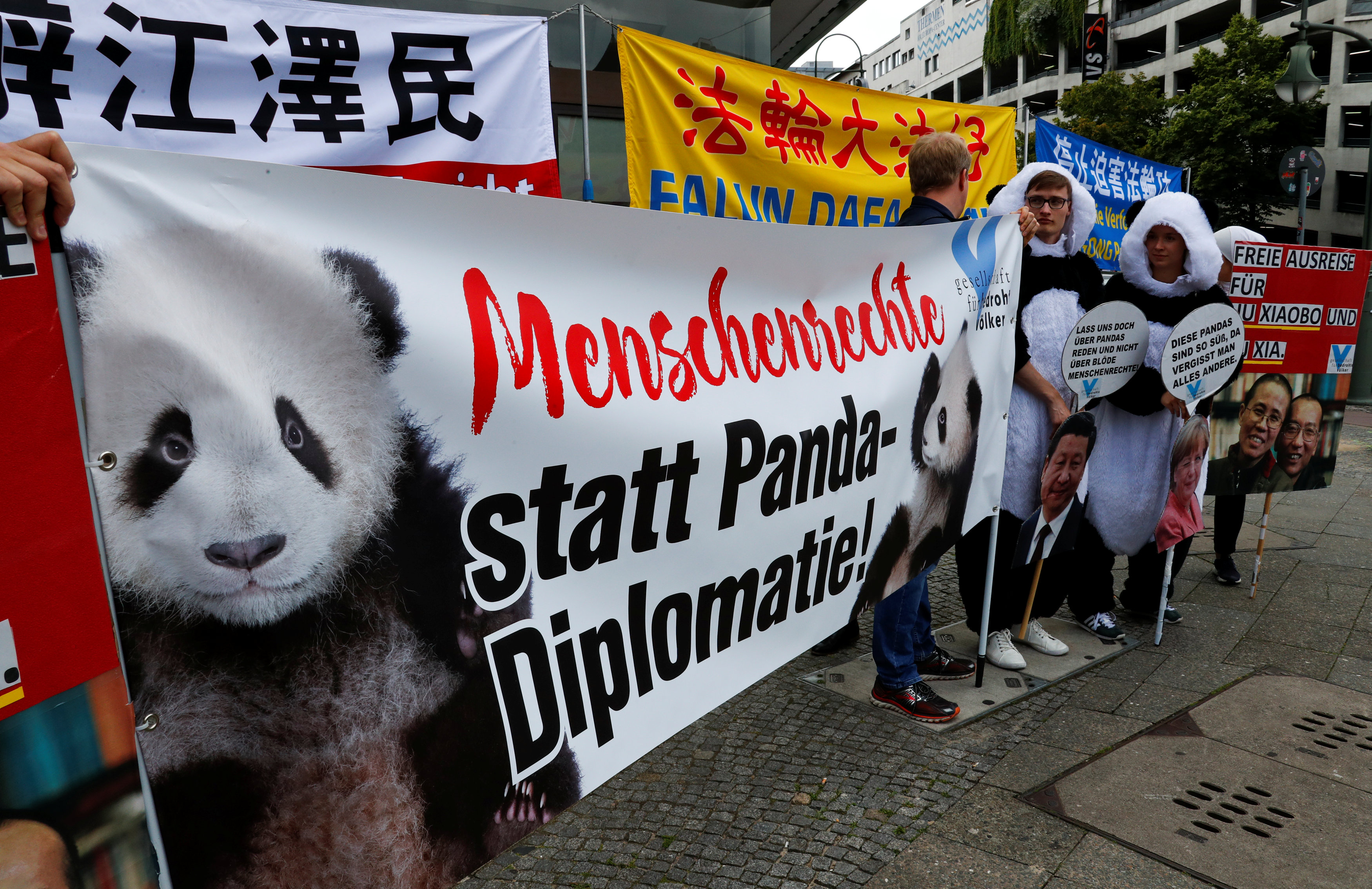 People protest before the arrival of German Chancellor Angela Merkel and Chinese President Xi Jinping at a welcome ceremony for Chinese panda bears Meng Meng and Jiao Qing, outside the Zoo in Berlin, Germany July 5, 2017. Banner reads, "Human rights instead of panda diplomacy". REUTERS/Fabrizio Bensch