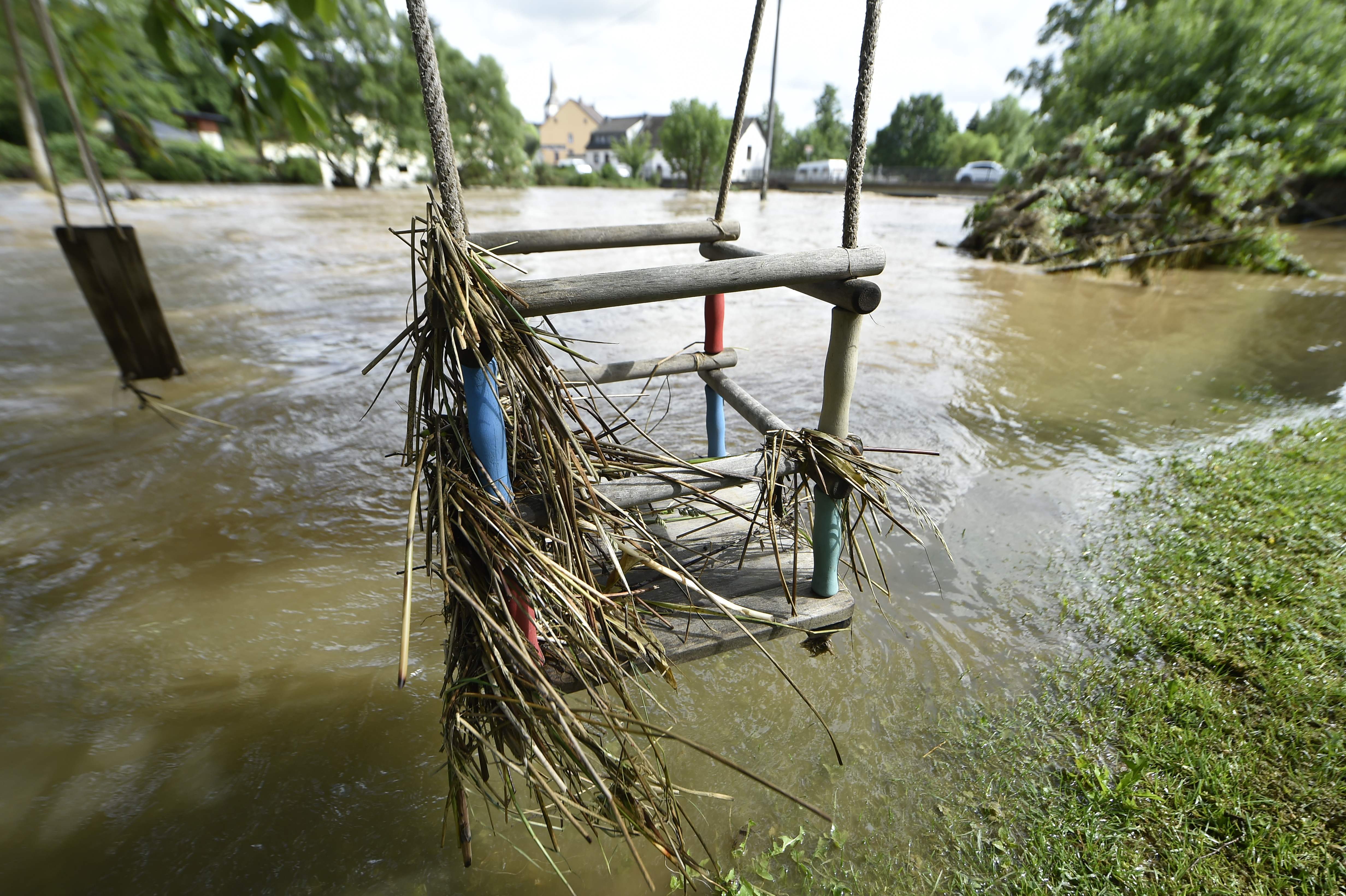 A swing in a flooded area of Luenebach, western Germany, is pictured on June 1, 2018, after heavy rainfalls hit southern and western parts of the country. Five dangerous predators, including two lions, two tigers and a jaguar escaped from a zoo in western Germany on Friday, sparking a massive hunt, a spokesman for the local authorities told AFP. / AFP PHOTO / JOHN THYS