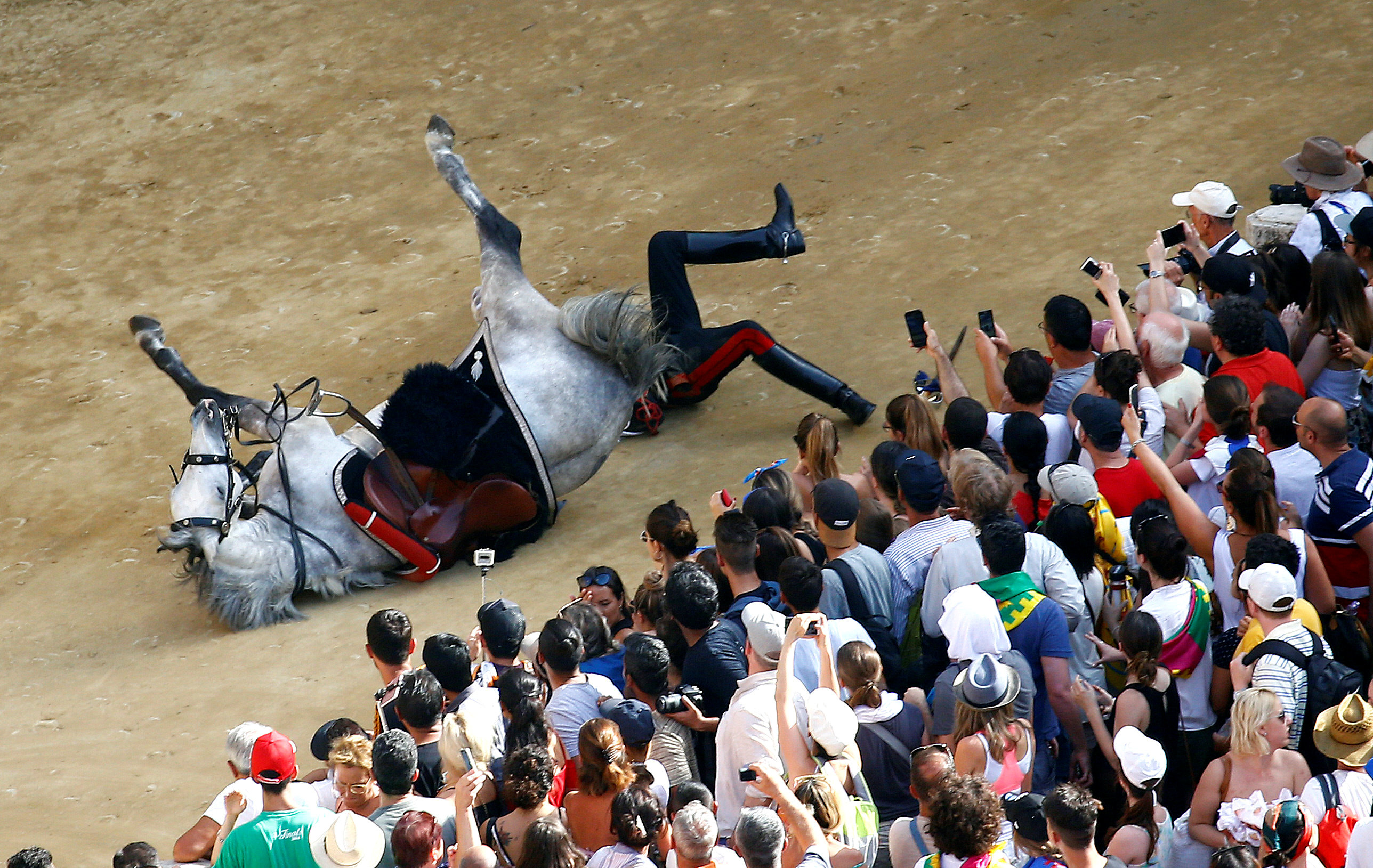 Italian Carabinieri police falls down from his horse during their parade prior the Palio of Siena horse race, Italy, July 2, 2018. REUTERS/Stefano Rellandini TPX IMAGES OF THE DAY