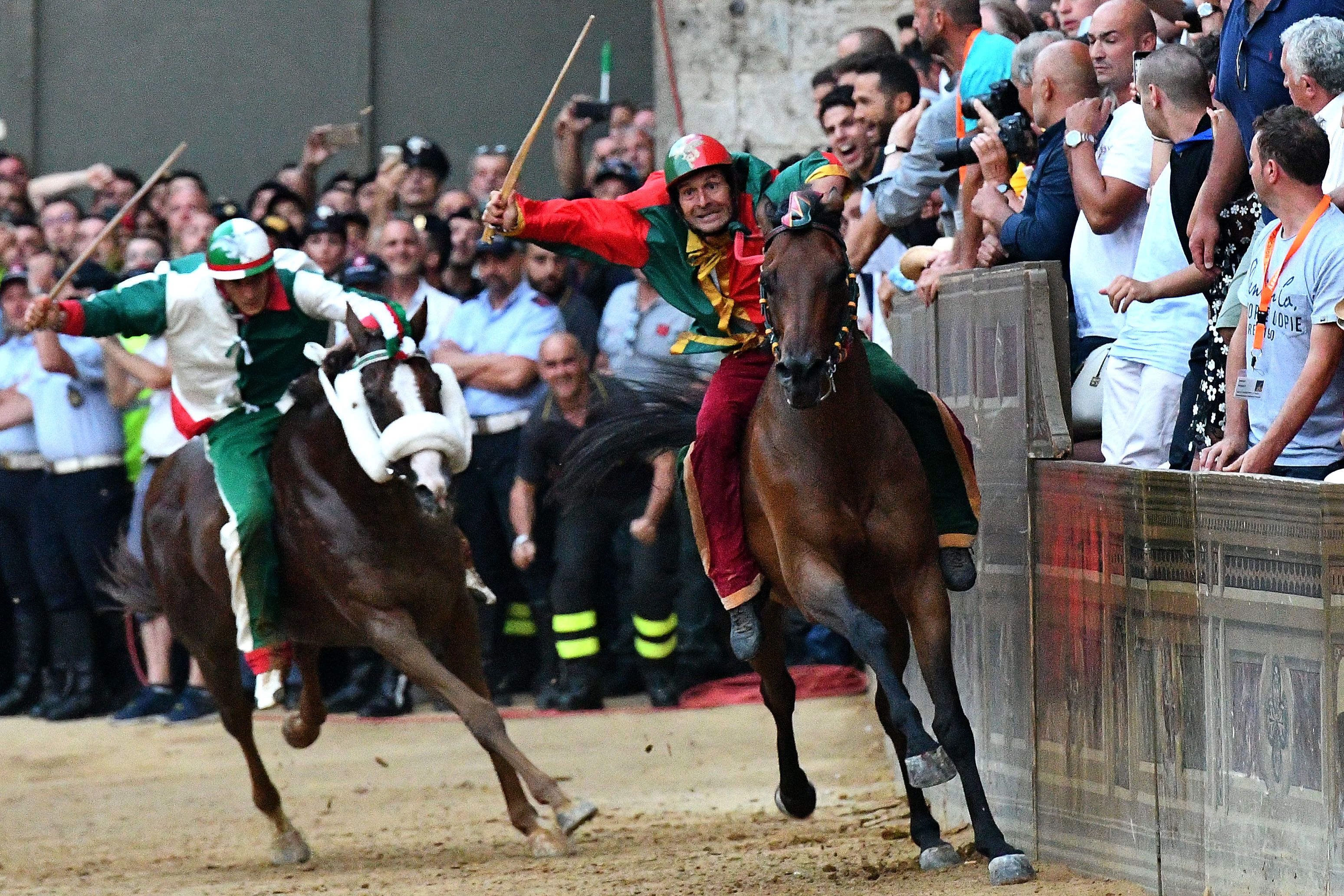 Jockey of the contrada "Drago" Andrea Mari (R) competes with his horse Rocco Nice and wins the historical Italian horse race Palio di Siena on July 2, 2018, in Siena. / AFP PHOTO / Vincenzo PINTO