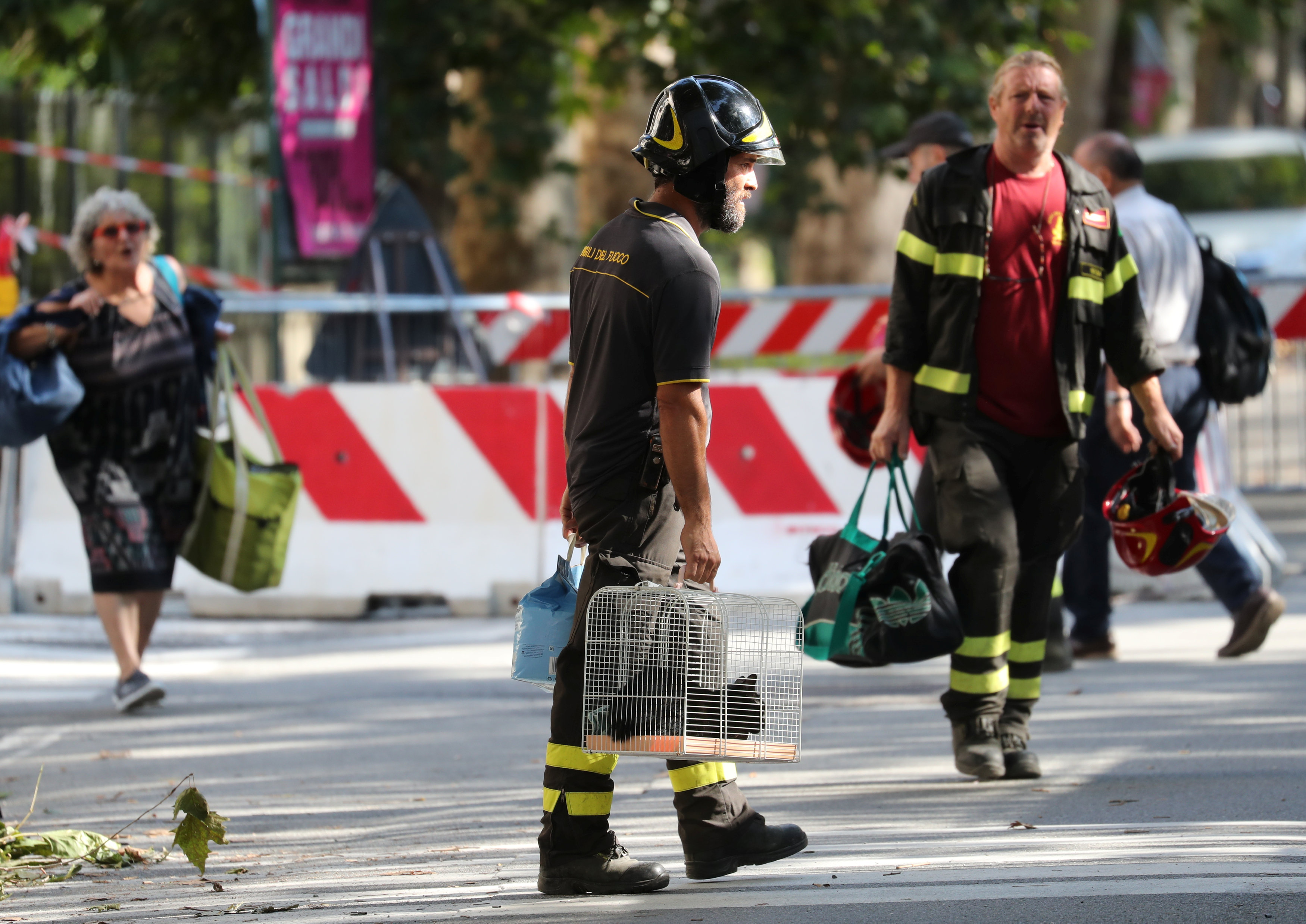 A firefighter carries a cat recovered from the houses near the collapsed Morandi Bridge, in the port city of Genoa, Italy August 16, 2018. REUTERS/Stefano Rellandini