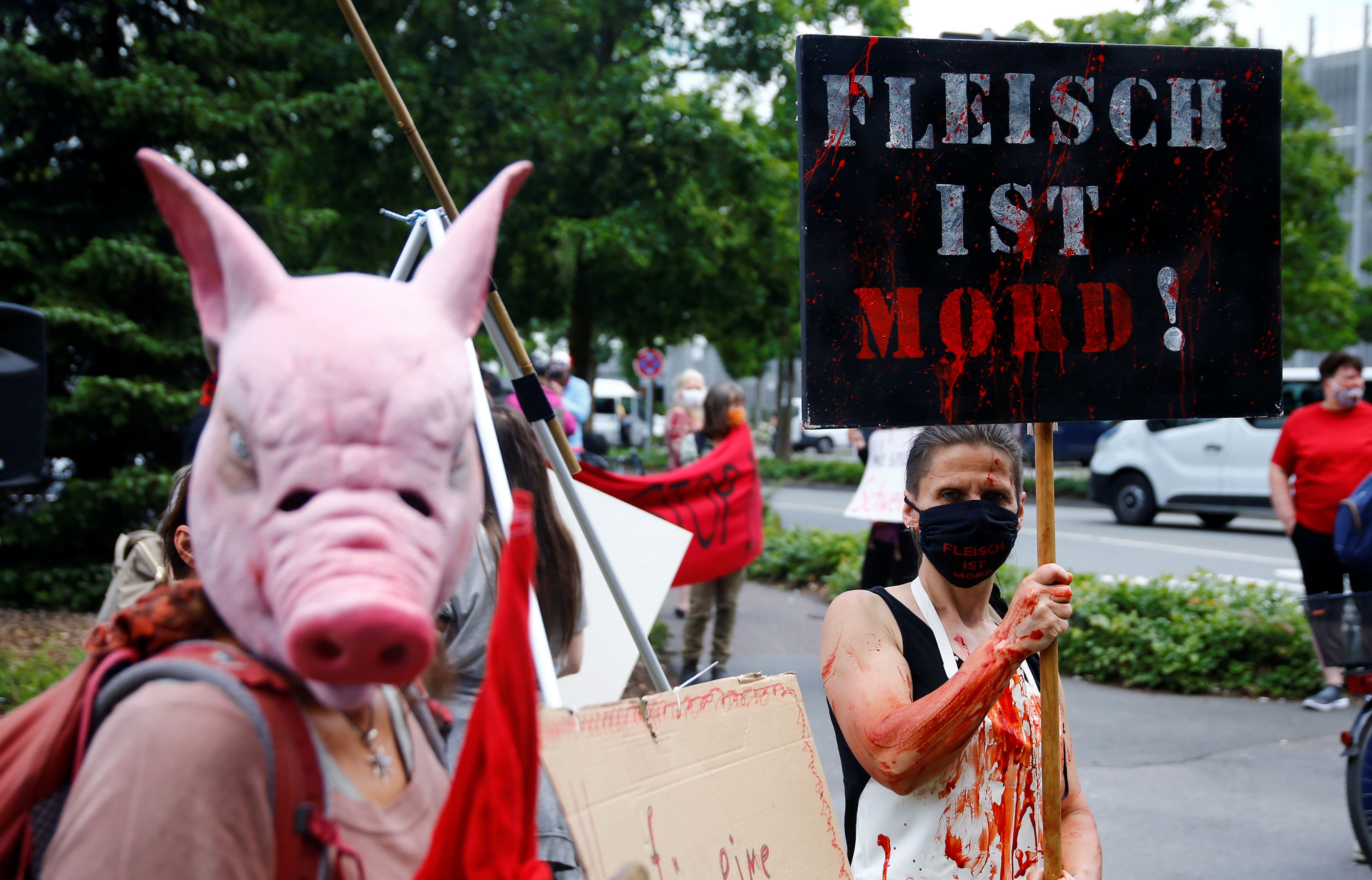 An activist holds a banner reading "Meat is murder" outside the main Toennies meat factory that had to be shut down because of the coronavirus disease (COVID-19) outbreak among its employees, in Rheda-Wiedenbrueck, Germany June 20, 2020. REUTERS/Leon Kuegeler